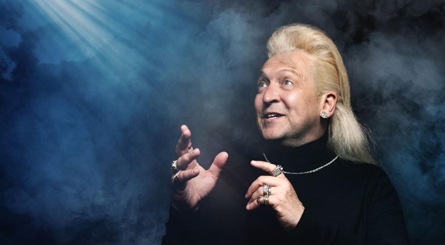 clinton baptiste against a black background with smoke around him