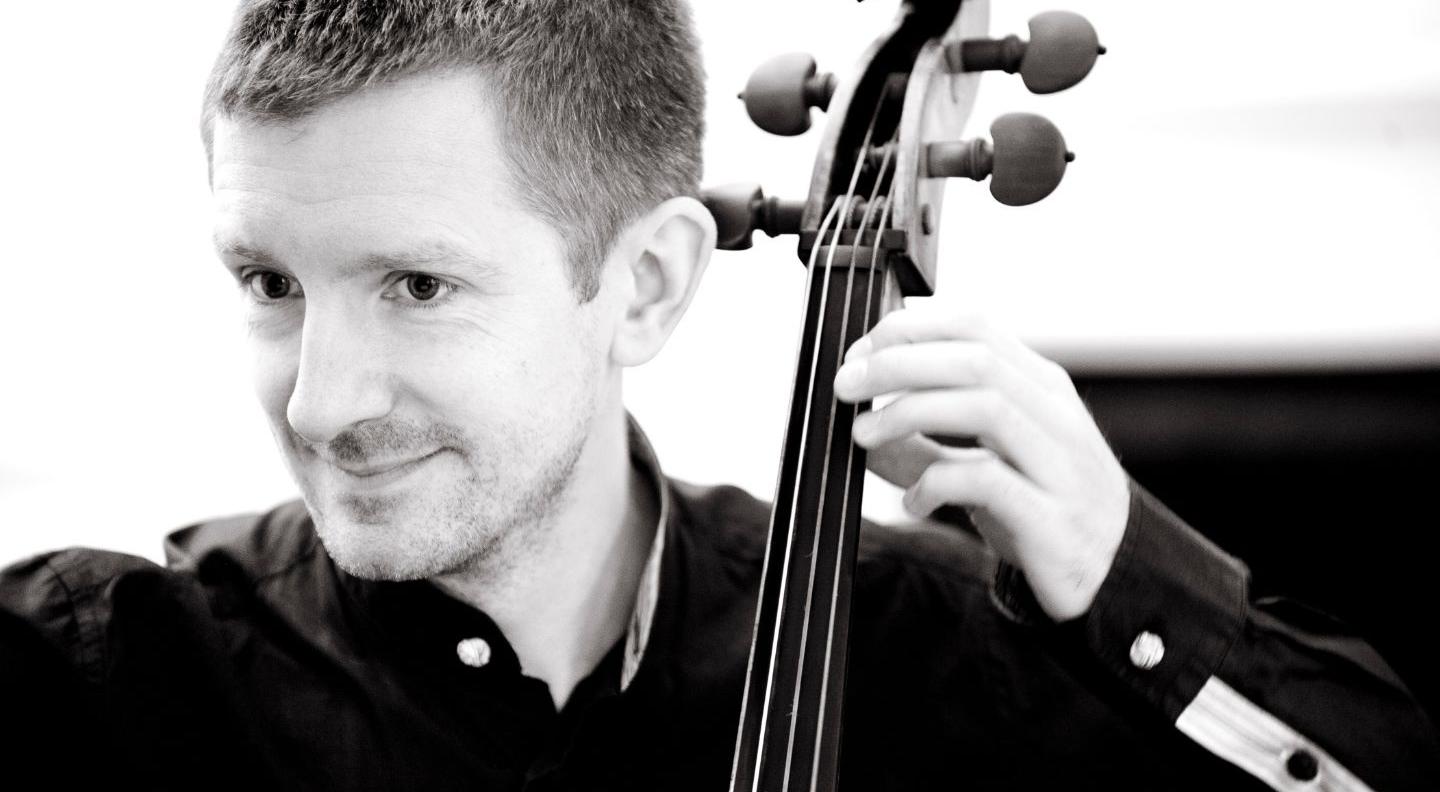 A black and white image of Jonathan playing the cello