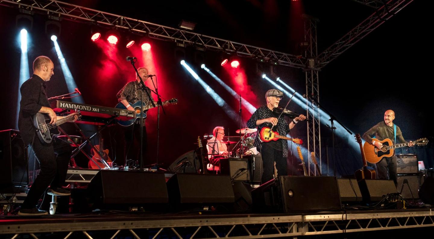 Folk-rock band Lindisfarne on stage, with red stage lighting