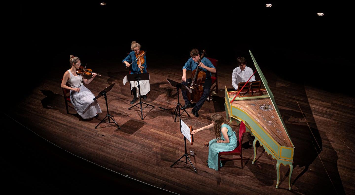 an image of the group playing on a darkened stage