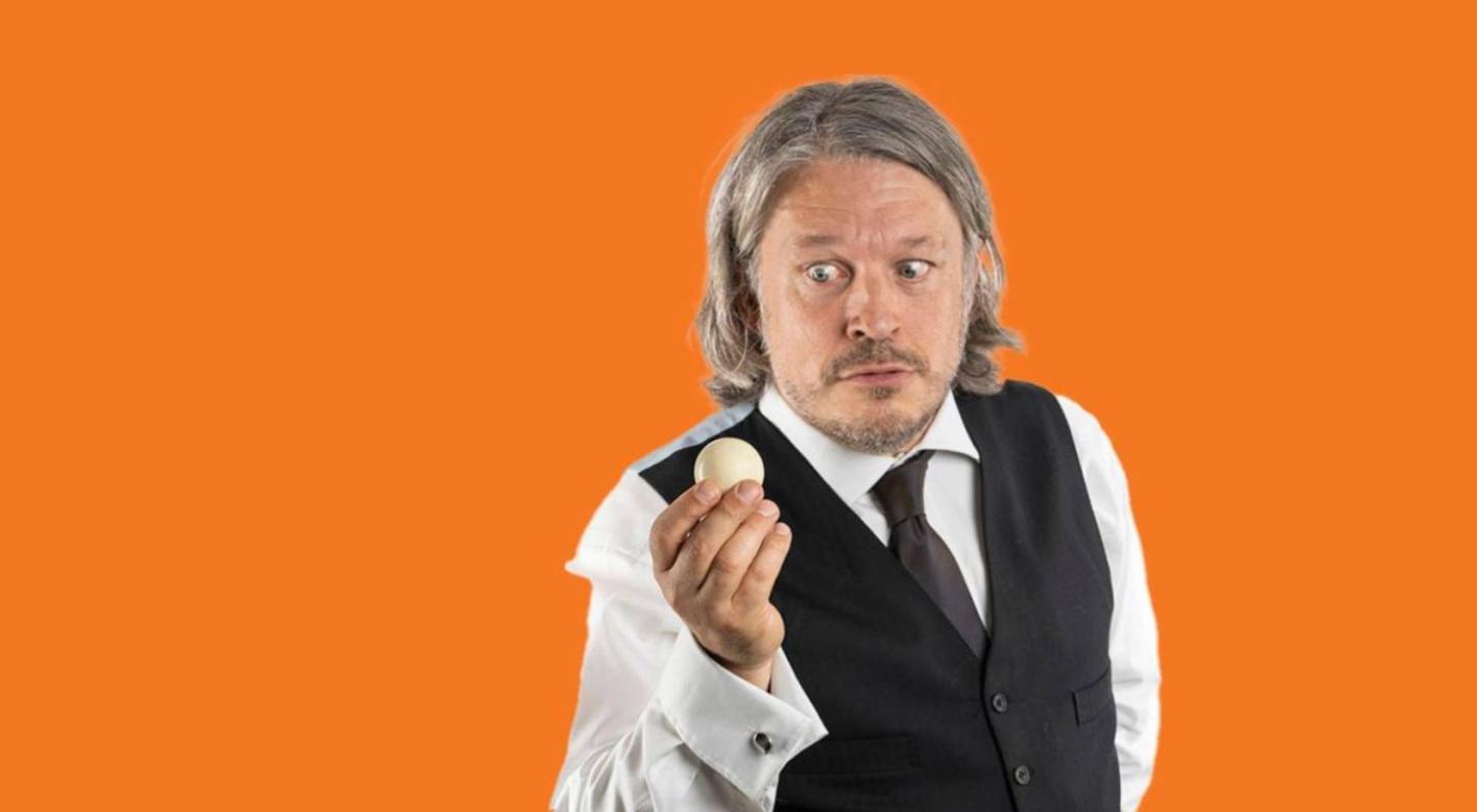 An image of Richard holding a ball against an orange background