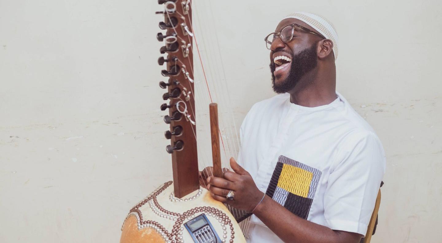 An image of Seckou Keita sitting, with his  Kora on his lap