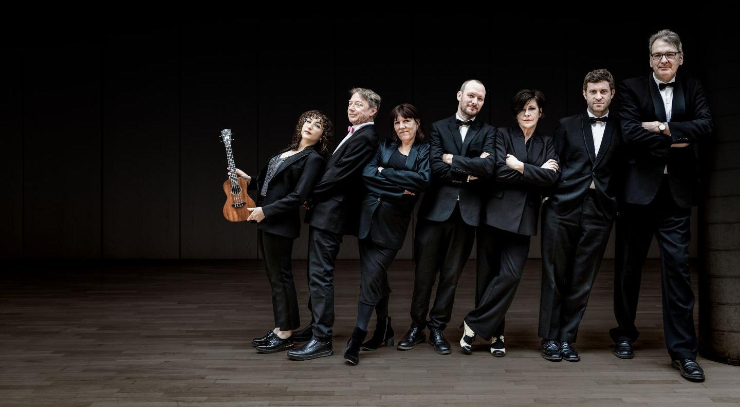 An image of the Ukelele Orchestra on a dark stage