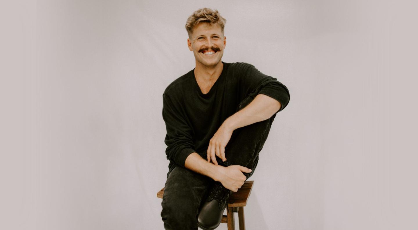 Ziggy Alberts sitting in front of a grey background.